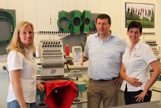 Tanja Mülders (links im Bild) und Marlies Barnjak Bartulovic (rechts im Bild) erklären Bürgermeister Ulrich Francken, wie die von ihnen vorbereiteten Stickmotive in der Stickerei TAMA maschinell umgesetzt werden . 