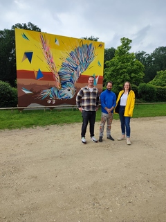 Bernd Dicks (San Hejmo GmbH, DACO (Künstler) und Stefanie Wolff (Schloss Hertefeld) zeigen das neue Kunstwerk.