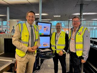 (v.l.n.r.) Regierungspräsident Thomas Schürmann, Dr. Sebastian Papst (Airport Weeze) und Bürgermeister Georg Koenen an der Sicherheitskontrolle im Airport Weeze