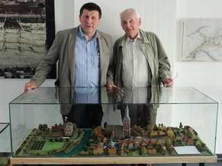 von links nach rechts: Bürgermeister Ulrich Francken freut sich über das neue historische Modell, das Heinrich Gerritzen von der Ortsmitte von Weeze angefertigt hat
