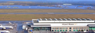 Das Terminal mit der dahinter liegenden Landebahn und den Solaranlagen