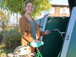 Sophie de Ryk ist froh, dass Sie das grüne NiederrheinRad in die Fahrradbox leicht rein und raus fahren kann